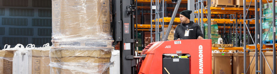 Equipment operator moving inventory with forklift